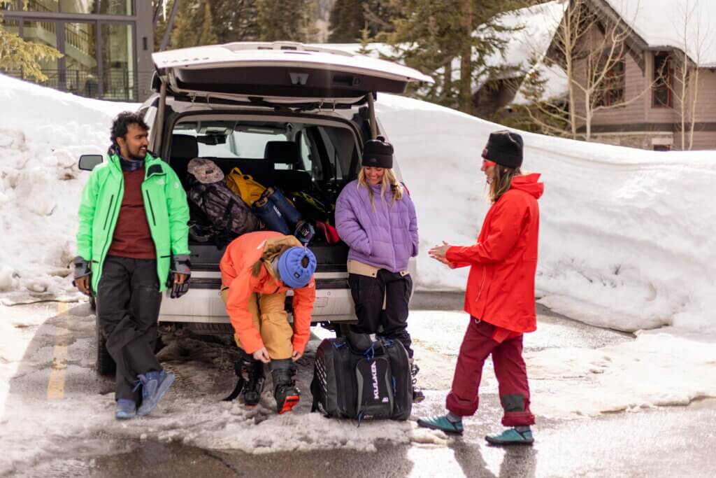 4 skiers at their car in a parking lot